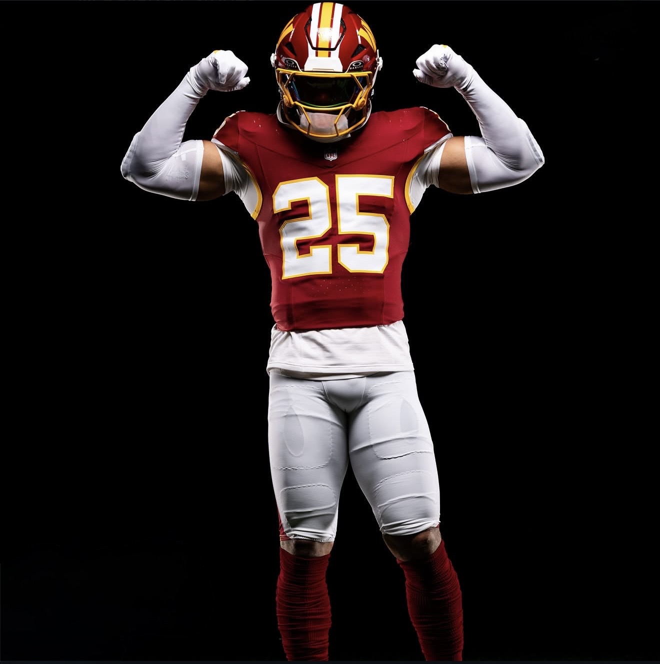 Nick Cross flexing in his Washington Commanders number 25 uniform